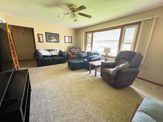 carpeted living area with a ceiling fan