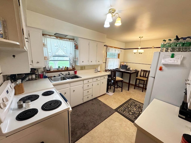 kitchen featuring white cabinets, a healthy amount of sunlight, a sink, and white appliances