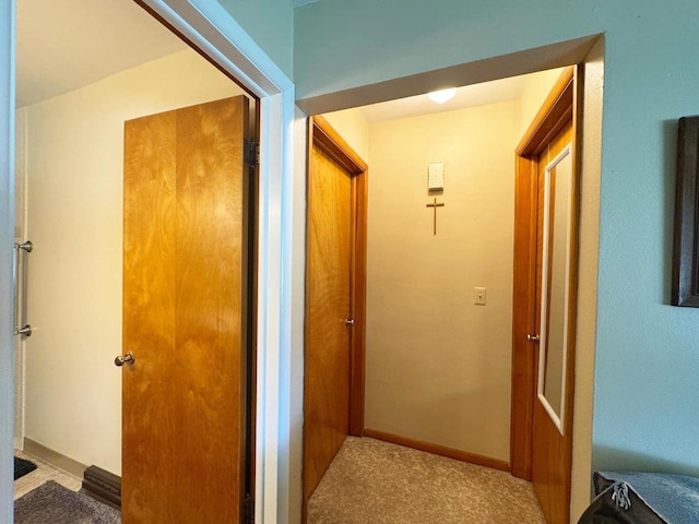 hallway with carpet floors and baseboards