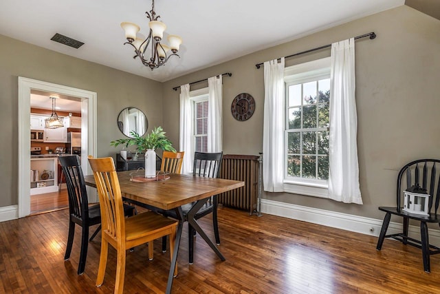 320 W Harrison St, Shullsburg, WI 53586 - dining space with visible vents, dark wood-style flooring, baseboards, and a notable chandelier