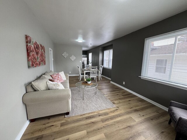 living area with baseboards and wood finished floors