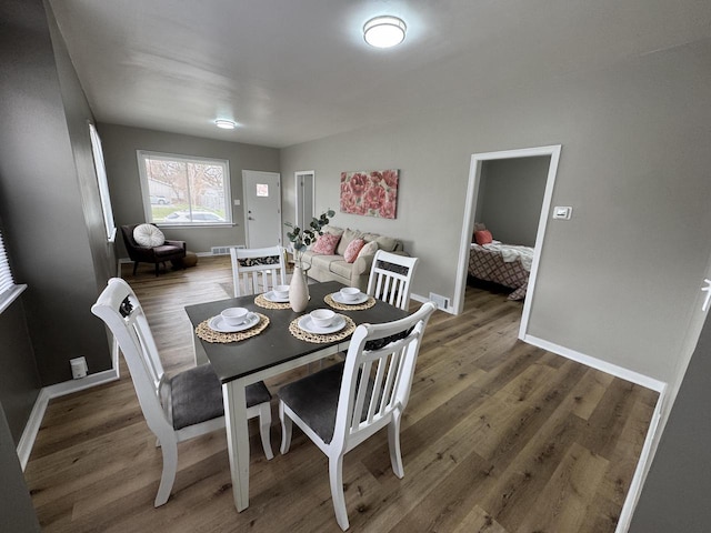 dining room featuring baseboards, visible vents, and wood finished floors