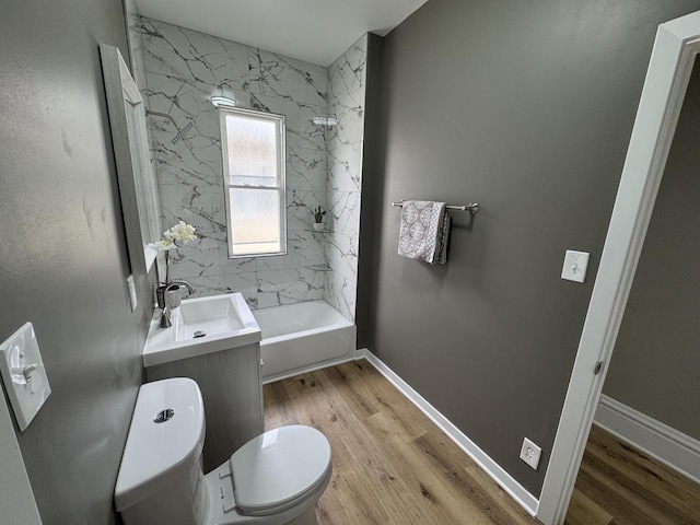 full bathroom with a sink, toilet, wood finished floors, shower / bath combination, and baseboards