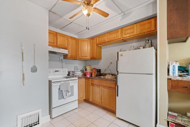 3423 S Clement Ave, Milwaukee, WI 53207 - kitchen with under cabinet range hood, light tile patterned floors, white appliances, ceiling fan, and visible vents