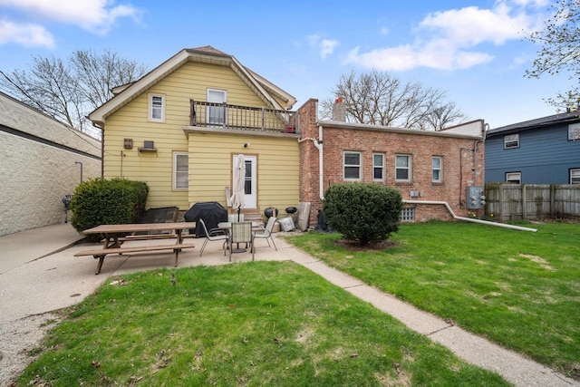 3423 S Clement Ave, Milwaukee, WI 53207 - rear view of house featuring a balcony, a patio, fence, and a lawn