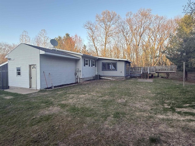 W5417 Volling Ln, Mauston, WI 53948 - rear view of house featuring a deck, a yard, and central AC