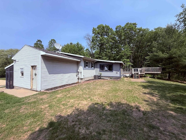 W5417 Volling Ln, Mauston, WI 53948 - rear view of property with a deck, a lawn, and central AC