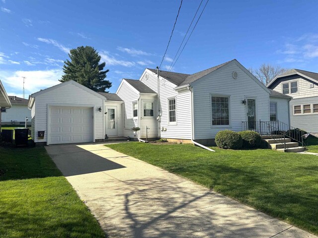 140 W Manchester St, Markesan, WI 53946 - bungalow-style house featuring concrete driveway, cooling unit, a front lawn, and an attached garage