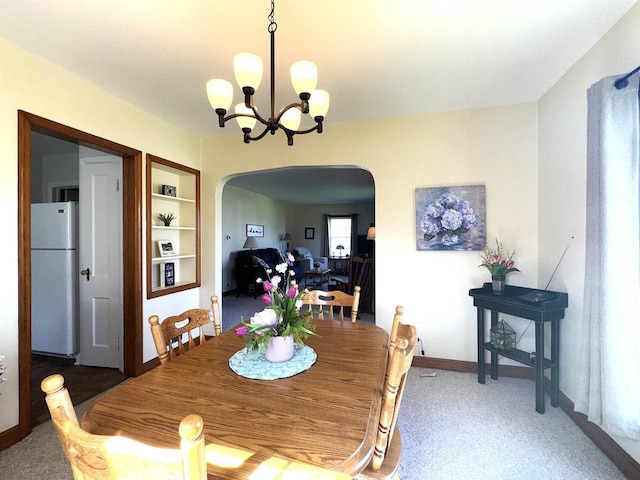 140 W Manchester St, Markesan, WI 53946 - carpeted dining area with a chandelier, arched walkways, baseboards, and built in features