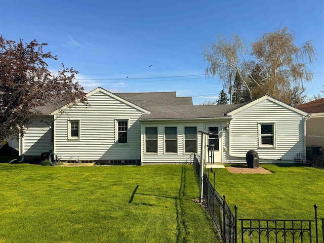 140 W Manchester St, Markesan, WI 53946 - rear view of house featuring a fenced backyard, roof with shingles, a yard, and central AC unit