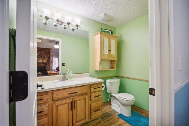 11 Fir Trl, Wisconsin Dells, WI 53965 - bathroom featuring vanity, toilet, a textured ceiling, and wood finished floors