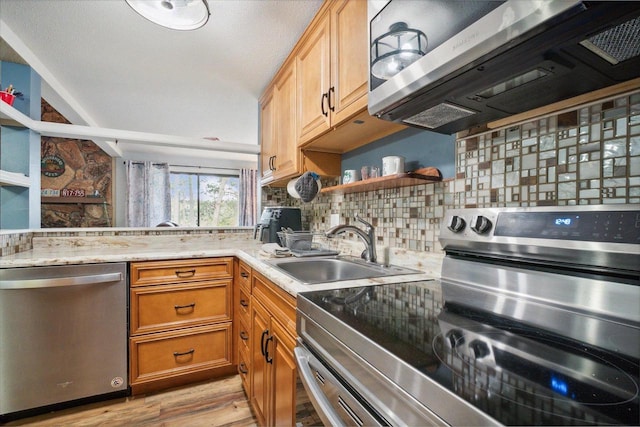 11 Fir Trl, Wisconsin Dells, WI 53965 - kitchen featuring a sink, open shelves, light wood-type flooring, appliances with stainless steel finishes, and decorative backsplash