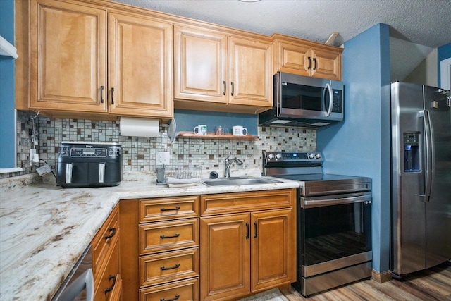 11 Fir Trl, Wisconsin Dells, WI 53965 - kitchen with light stone counters, stainless steel appliances, tasteful backsplash, and a sink