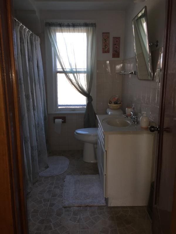 2753 N 60th St Unit 2755, Milwaukee, WI 53210 - full bathroom featuring curtained shower, vanity, tile walls, and toilet