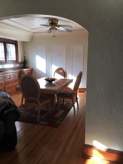 2753 N 60th St Unit 2755, Milwaukee, WI 53210 - dining area featuring ceiling fan, a textured wall, arched walkways, and light wood-type flooring