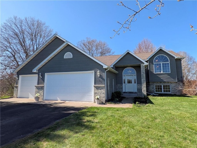 1380 101st Cir, Amery, WI 54001 - view of front of house with an attached garage, asphalt driveway, a front lawn, and brick siding
