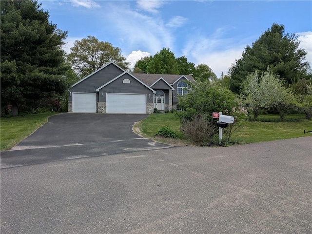 1380 101st Cir, Amery, WI 54001 - view of front of home featuring driveway, a garage, stone siding, a front lawn, and view of scattered trees