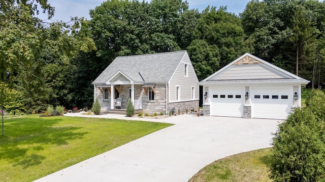1430 Park Ave, West Bend, WI 53090 - view of front facade featuring stone siding, a detached garage, a front yard, covered porch, and an outdoor structure