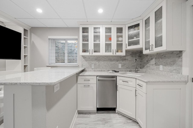 1430 Park Ave, West Bend, WI 53090 - kitchen featuring stainless steel dishwasher, a peninsula, white cabinetry, light stone countertops, and light marble finish flooring