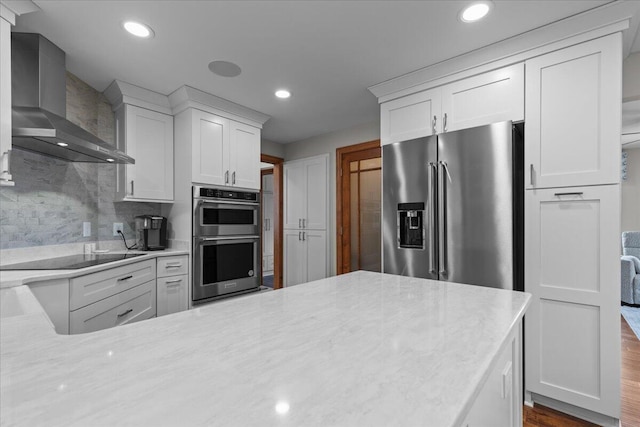 1430 Park Ave, West Bend, WI 53090 - kitchen with wall chimney range hood, stainless steel appliances, white cabinetry, and recessed lighting