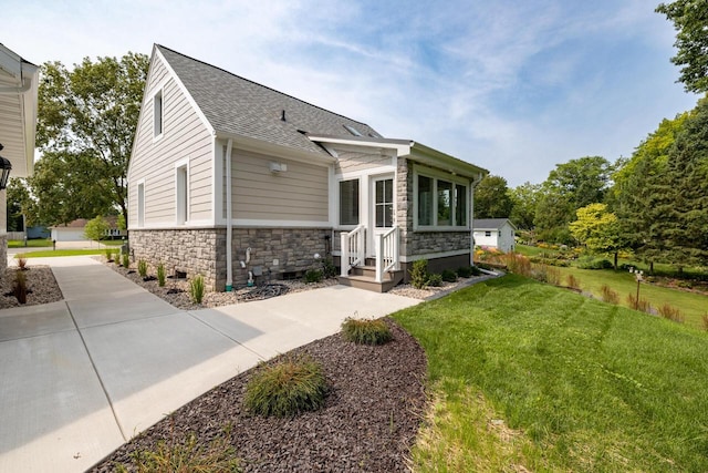 1430 Park Ave, West Bend, WI 53090 - view of front of house featuring stone siding, a shingled roof, and a front yard