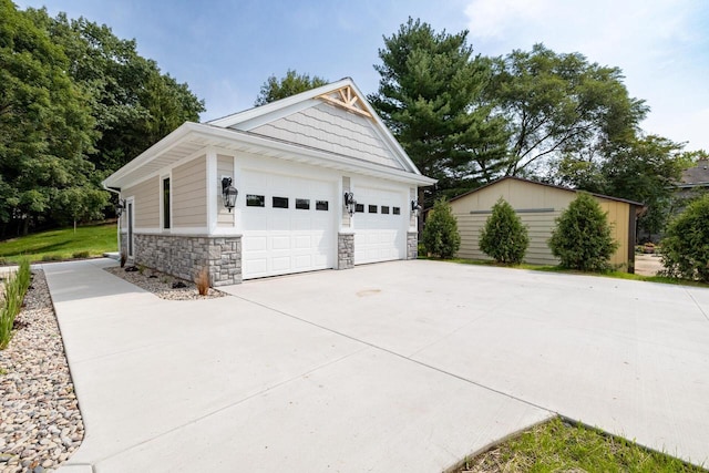 1430 Park Ave, West Bend, WI 53090 - view of side of property with stone siding, an outdoor structure, and a garage