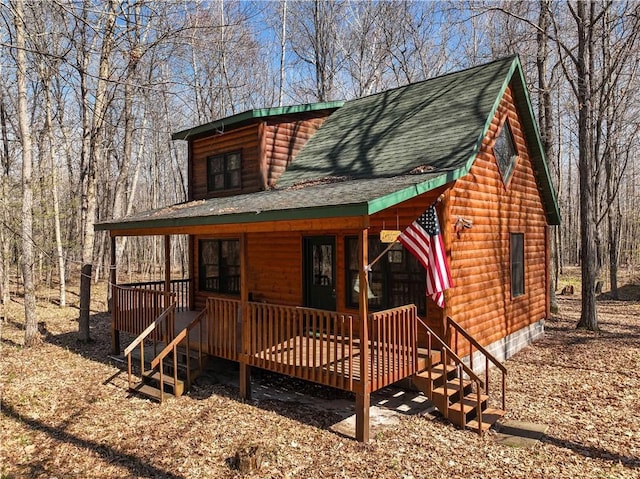 1687 Evergreen Path, Spooner, WI 54801 - view of front of house featuring a porch, roof with shingles, and faux log siding
