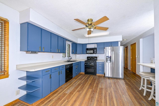 7113 E County Rd E, South Range, WI 54874 - kitchen featuring black appliances, blue cabinets, open shelves, a textured ceiling, and dark wood-style floors