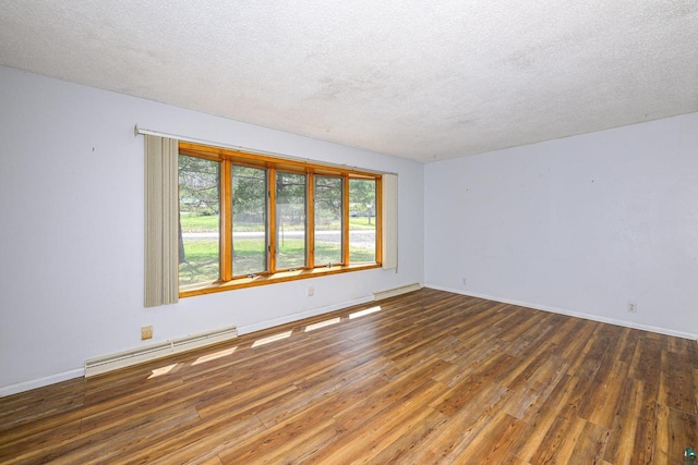 7113 E County Rd E, South Range, WI 54874 - unfurnished room featuring a baseboard heating unit, hardwood / wood-style flooring, plenty of natural light, and a textured ceiling