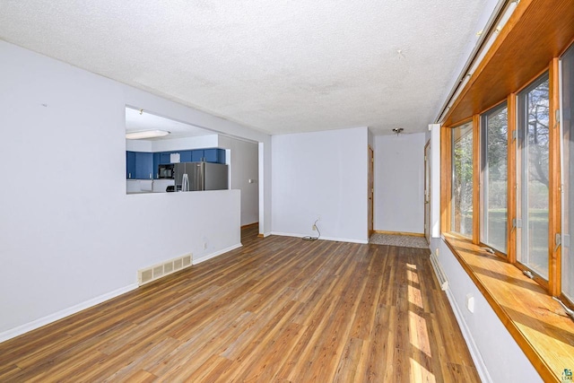 7113 E County Rd E, South Range, WI 54874 - unfurnished living room with a textured ceiling, wood finished floors, and baseboards