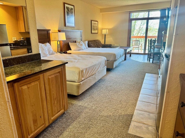 2504 River Rd Unit 7218, Wisconsin Dells, WI 53965 - bedroom with light carpet, access to outside, freestanding refrigerator, and a textured wall