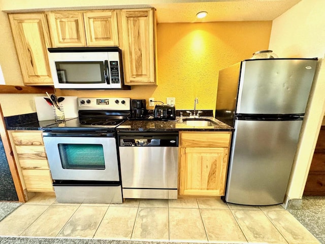 2504 River Rd Unit 7218, Wisconsin Dells, WI 53965 - kitchen featuring stainless steel appliances, a sink, light brown cabinetry, a textured wall, and light tile patterned floors