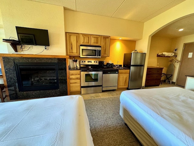 2504 River Rd Unit 7218, Wisconsin Dells, WI 53965 - bedroom featuring freestanding refrigerator, a sink, arched walkways, a glass covered fireplace, and light tile patterned flooring