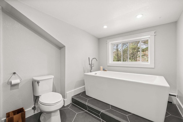 175 Old Wausau Rd, Stevens Point, WI 54481 - bathroom with toilet, a freestanding bath, tile patterned flooring, recessed lighting, and baseboard heating