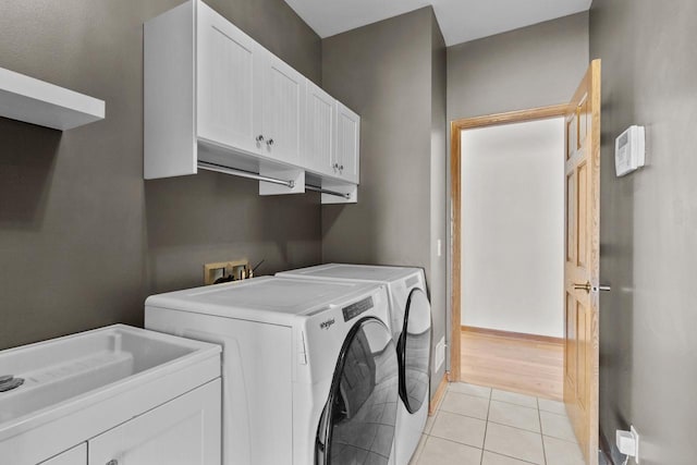 580 S Stone Ridge Dr, Lake Geneva, WI 53147 - laundry room featuring washing machine and dryer, cabinet space, light tile patterned flooring, and baseboards