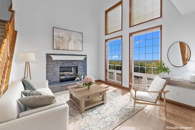 580 S Stone Ridge Dr, Lake Geneva, WI 53147 - living room with a high ceiling, wood finished floors, baseboards, stairs, and a stone fireplace