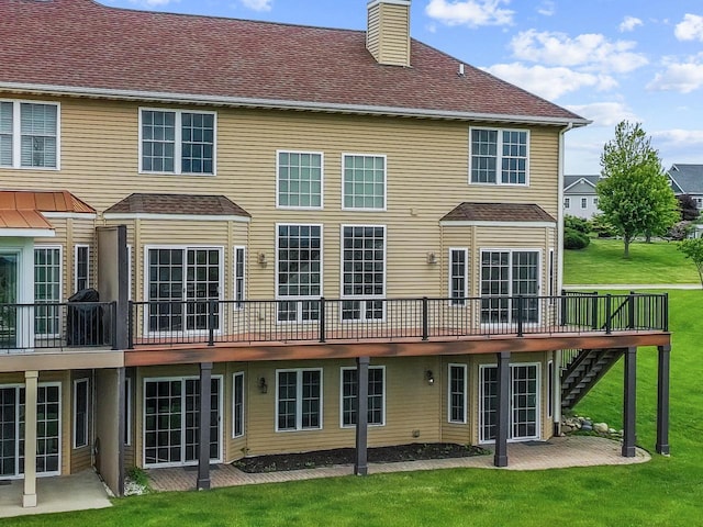580 S Stone Ridge Dr, Lake Geneva, WI 53147 - rear view of house with a chimney, a lawn, a wooden deck, a patio area, and stairs