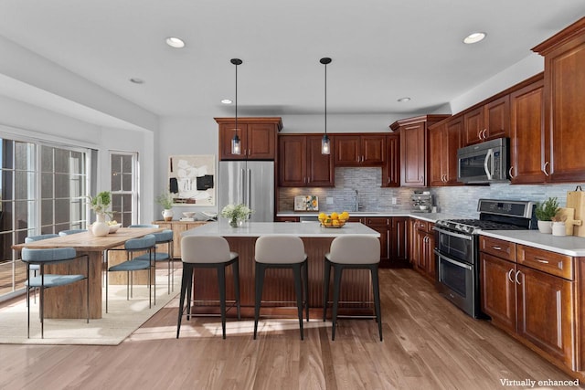 580 S Stone Ridge Dr, Lake Geneva, WI 53147 - kitchen featuring appliances with stainless steel finishes, a sink, light countertops, light wood-style floors, and tasteful backsplash
