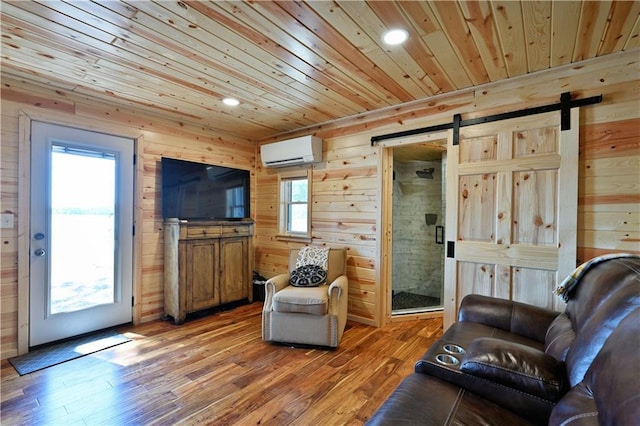 2097 Sunnyside Rd, Danbury, WI 54830 - living area with a barn door, a wall mounted AC, wooden walls, wood ceiling, and light wood finished floors