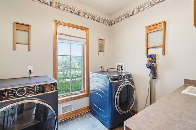 washroom featuring baseboards, separate washer and dryer, and stone finish flooring
