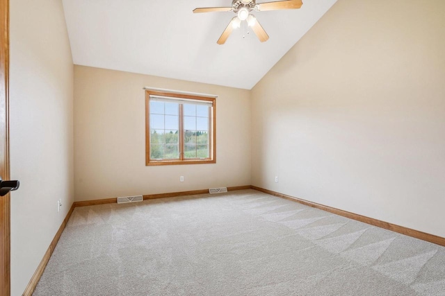 spare room featuring a ceiling fan, light colored carpet, lofted ceiling, and baseboards