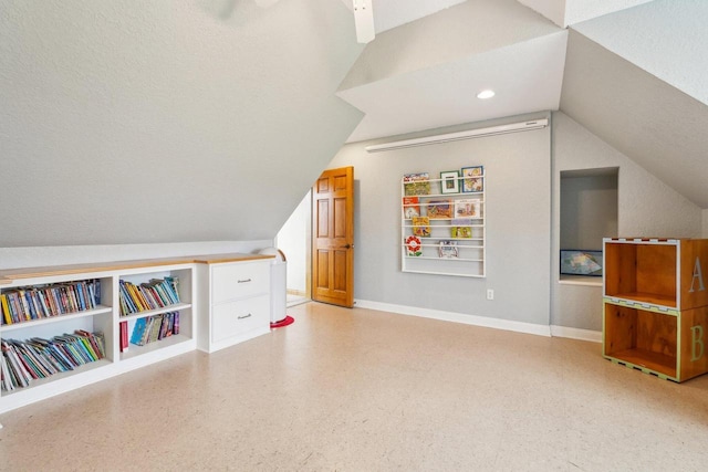 bonus room with vaulted ceiling, baseboards, and dark aggregate flooring