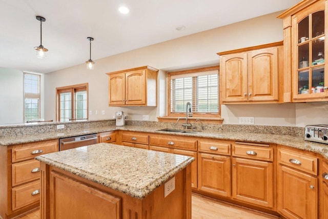 kitchen with a sink, stainless steel dishwasher, light stone counters, glass insert cabinets, and a center island