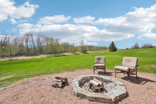 view of grassy yard with a fire pit