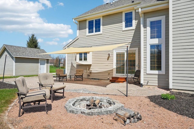 rear view of house with a patio, a fire pit, an outdoor structure, and entry steps