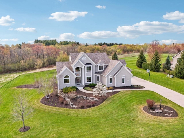 view of front facade with curved driveway and a front lawn