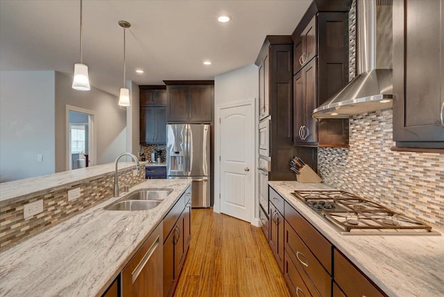 824 Richard Way, Waunakee, WI 53597 - kitchen featuring appliances with stainless steel finishes, a sink, wall chimney exhaust hood, light stone countertops, and decorative backsplash