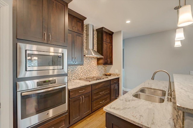 824 Richard Way, Waunakee, WI 53597 - kitchen featuring stainless steel appliances, a sink, wall chimney exhaust hood, backsplash, and dark brown cabinetry