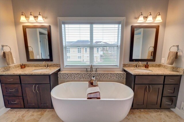 824 Richard Way, Waunakee, WI 53597 - bathroom featuring a freestanding bath, two vanities, and baseboards