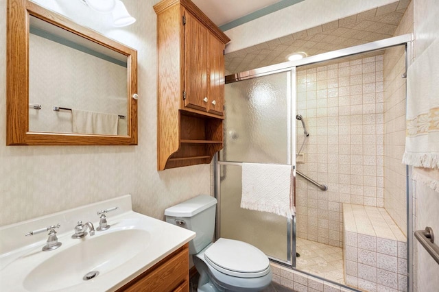 bathroom with toilet, a shower stall, and vanity